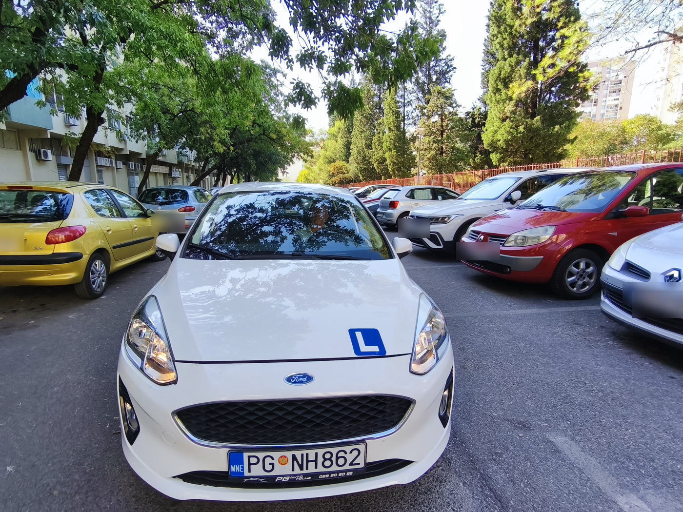 Vozilo škole sprijeda, sa plavom L oznakom na haubi